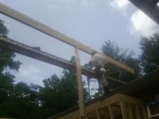 Carpenter setting a ridge beam over a new addition frame — Ice Dam Removal by Roofing Brothers in Winneconne
