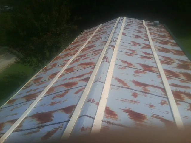 Rusted metal roof panels with new wood purlins before replacement — Storm Damage Roof Repair in Winneconne by Roofing Brothers
