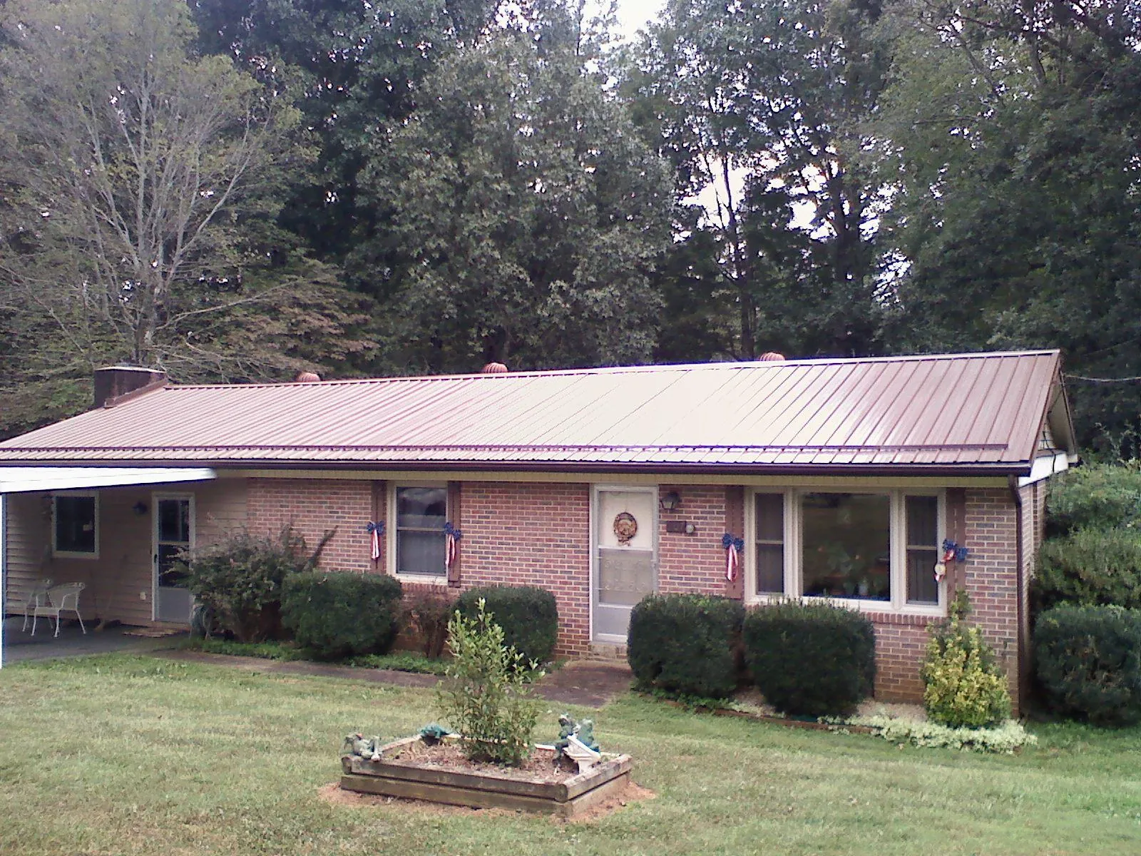 Bronze metal roof on a brick ranch home with a carport in Winneconne