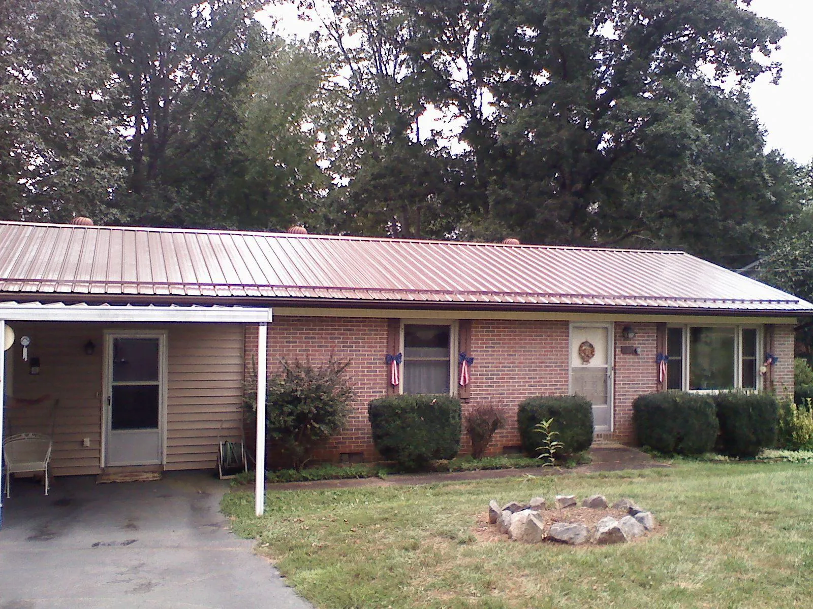Bronze metal roof and carport on a brick ranch home — Roof Repair work by our crew in Winneconne
